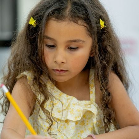 girl writing with a pencil