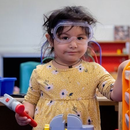 girl doing a science experiment wearing goggles