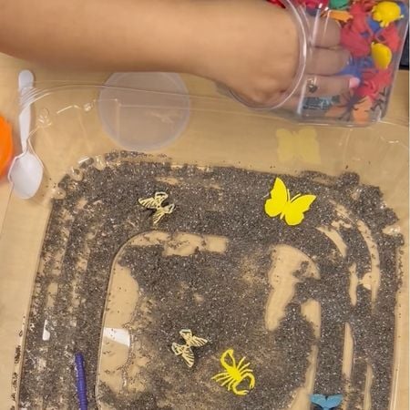 placing toy insects into the bin