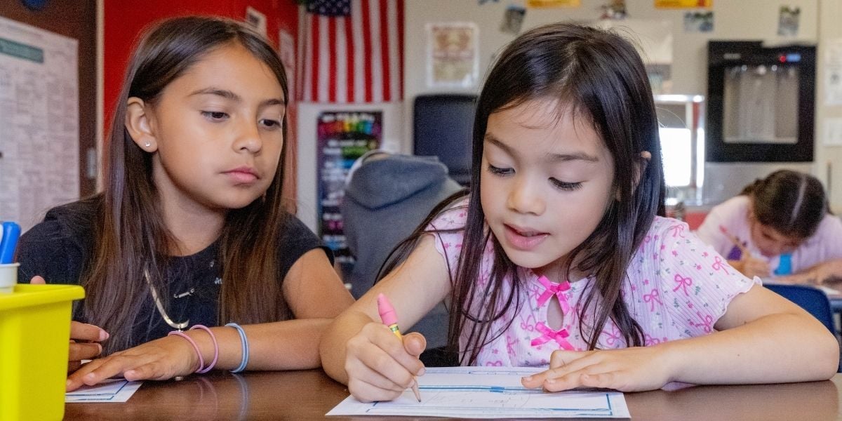 two young girls working on an assignment 