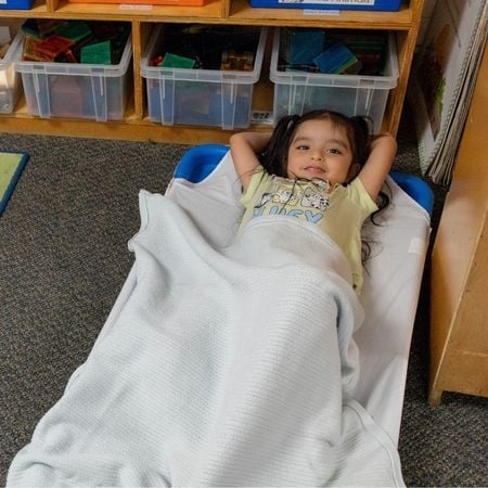 little girl at nap time on a cot
