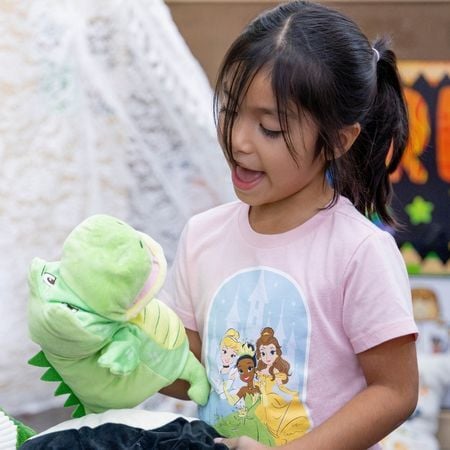 girl playing with alligator puppet