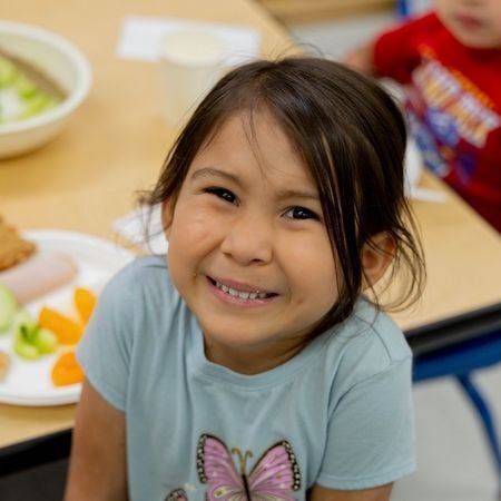 young preschool girl smiling in classroom