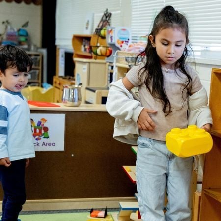 a girl and boy playing with big Legos