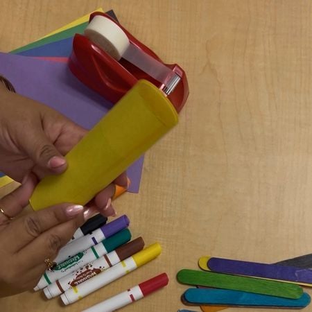 taping a piece of construction paper to a toilet paper roll