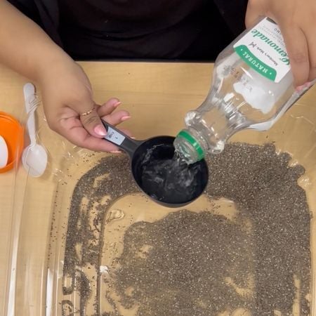 pouring water into a plastic storage tub