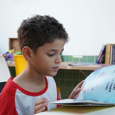 a young boy reads from a book