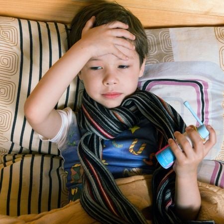 boy lying down with his hand on his head