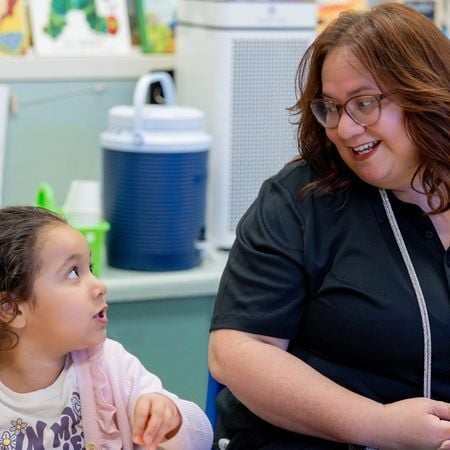 teacher smiling at a girl in the classroom