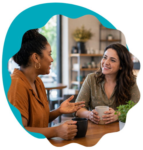 Two diverse women talking over coffee