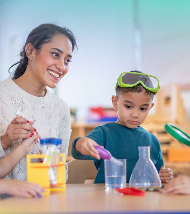 Child care provider with boy doing science experiment